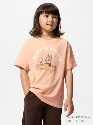 orange t-shirt with a labubu and a skeleton graphic and we are the monsters text on the front.