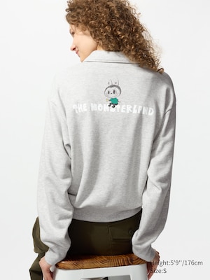 long sleeved, light grey sweatshirt with a we are the monsters logo on the front and a labubu sitting on the monsterland text on the back.